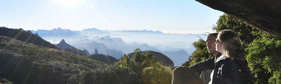 Sob a enorme rocha do Castelo do Açu, admirando a beleza do Parque Nacional da Serra dos Órgãos, no Rio de Janeiro